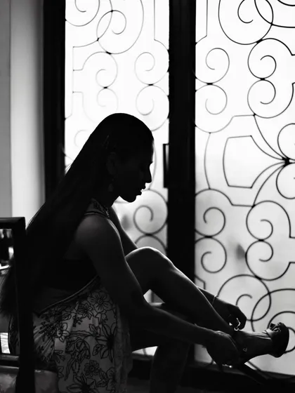 A black and white silhouette of Anasuya Sengupta against an ornate window. This is a great example of using shadow to create a dramatic and artistic portrait.