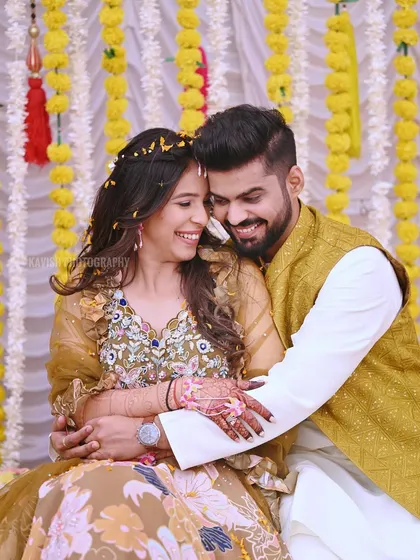 Another joyful portrait from the Haldi ceremony, capturing the couple's happy smiles and the festive atmosphere.