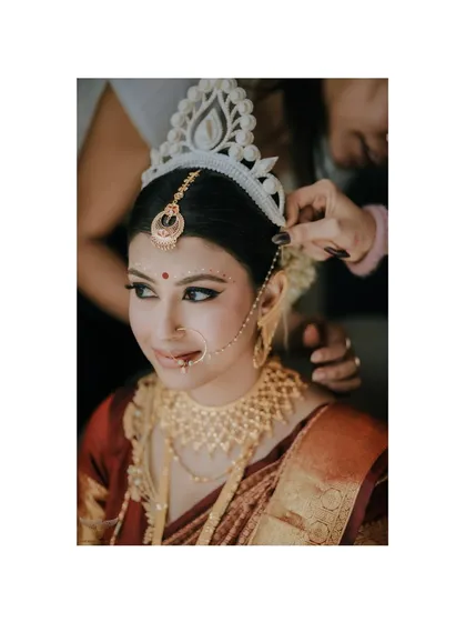 The final touches are always special. We captured the moment the traditional 'Mukut' is placed on the bride's head, a significant and beautiful part of the Bengali wedding ritual.