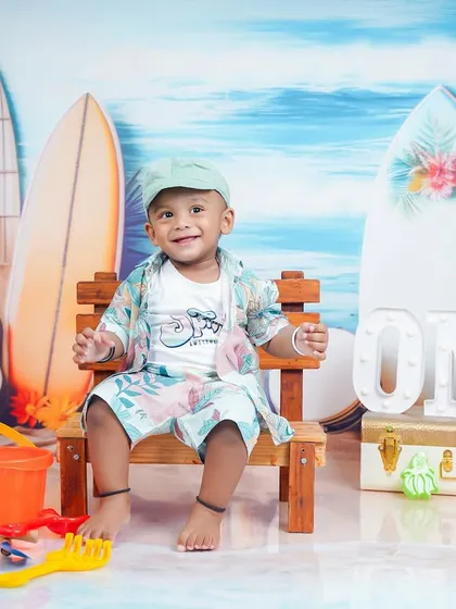 A relaxed and happy portrait of the birthday boy on his beach-themed set.