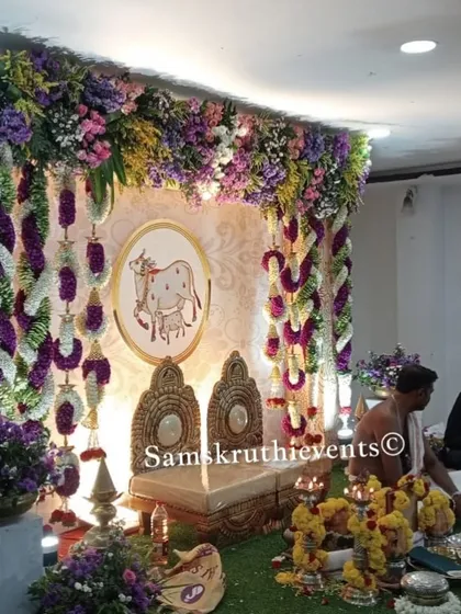 A pooja setup with two priests performing rituals in front of our elegant floral backdrop. We ensure the decoration complements the sanctity of the ceremony.