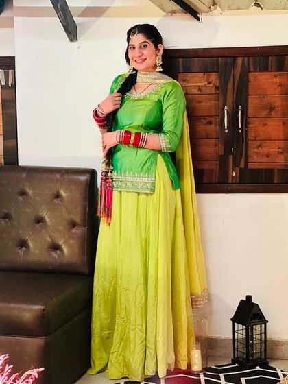 A full-length shot of the bright and festive green and yellow suit. It's a comfortable and stylish option for pre-wedding celebrations.