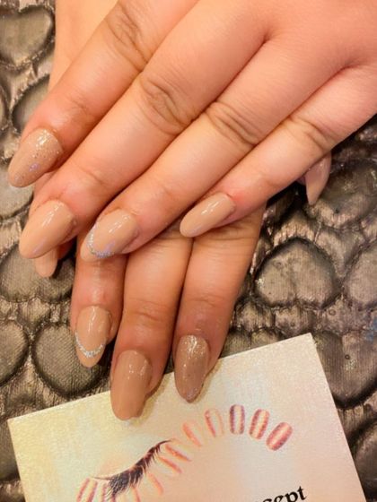 A simple and elegant set of almond-shaped nails in a sheer nude polish. A subtle silver glitter line on the accent nail adds a tiny hint of sparkle.