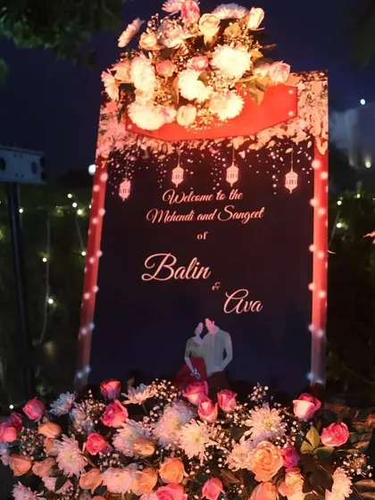 A personalized welcome sign for a Mehendi and Sangeet night. The dark background with hanging lanterns and a custom couple illustration makes for a romantic and inviting entrance.