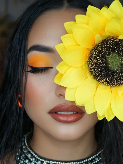 An artistic close-up showing the vibrant orange eyeshadow on a closed lid, a perfect shot for a makeup artist's portfolio.