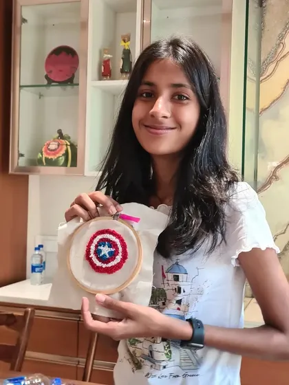 How cool is this. A young Marvel fan proudly displays her Captain America shield punch needle art. You can create any design you love.