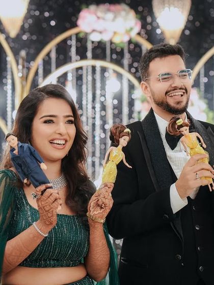 A fun and personal touch for the reception. Pragya and Akhil showing off custom-made dolls of themselves, a quirky detail that brought smiles to everyone's faces.
