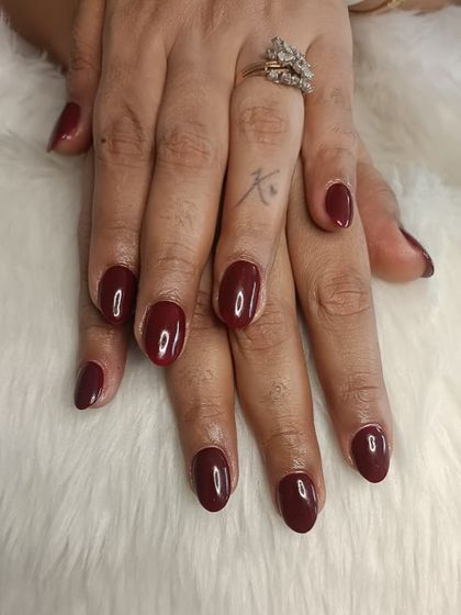 A recap photo of a classic deep red manicure on natural nails.
