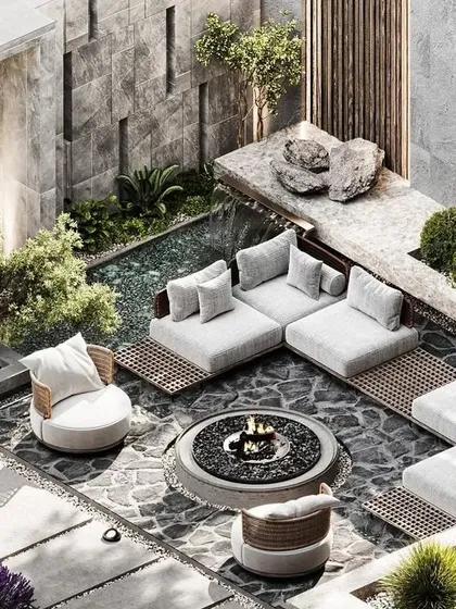 An isometric view of a modern sunken lounge concept, designed for intimate gatherings. This outdoor living space features a central fire pit, custom stone flooring, and integrated planters, all enclosed by a textured stone wall with a gentle water feature for ambient sound.