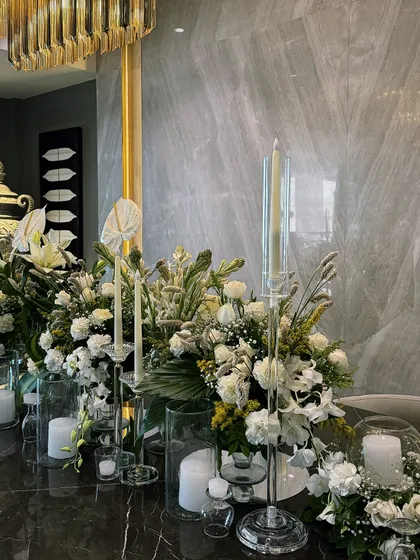 The full tablescape for a modern Diwali dinner. The clean lines of the candles and the lushness of the flowers create a balanced and beautiful centerpiece.