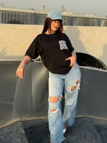 An oversized black t-shirt paired with ripped baggy jeans and a denim cap for ultimate comfort.