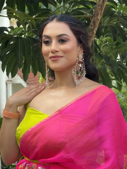 A bold and modern look for a sister's Haldi ceremony, featuring a vibrant pink and lime green saree.