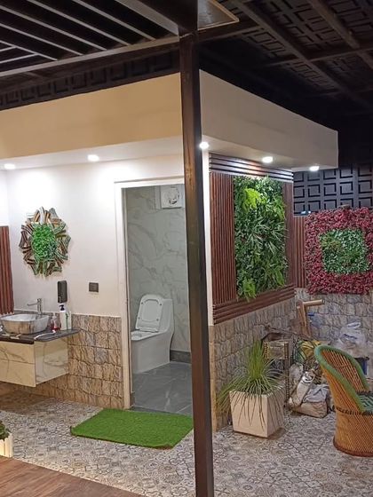 A fully equipped rooftop washroom at the Najafgarh site, complete with a sink, toilet, and decorative green wall panels.