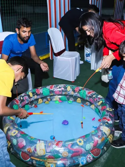 Kids and adults enjoying the "catching fish" game, one of the many interactive booths at the carnival party.