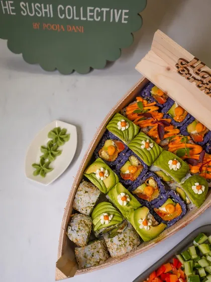 A vibrant, top-down photograph of a sushi platter presented in a unique boat-shaped wooden box. This food presentation shot is perfect for restaurant menus, social media, and delivery platform marketing.