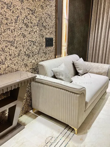 A sophisticated living room arrangement featuring a channel-tufted loveseat, blue high-back chairs, and a natural onyx marble coffee table. The mix of textures and forms creates a refined and elegant space.
