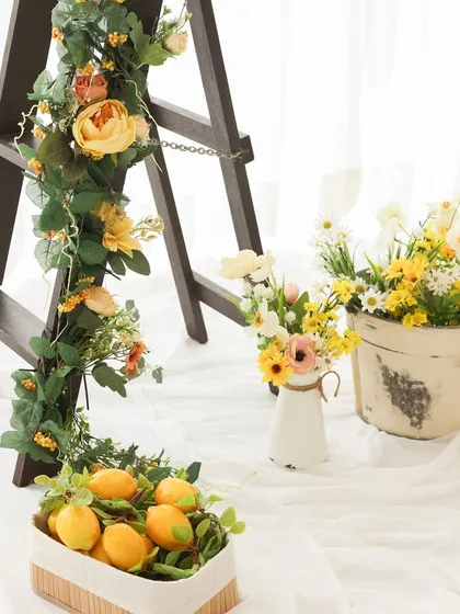A touch of rustic charm. The combination of the wooden ladder, floral garlands, and baskets of lemons creates a beautiful, layered look for our lemon garden theme.