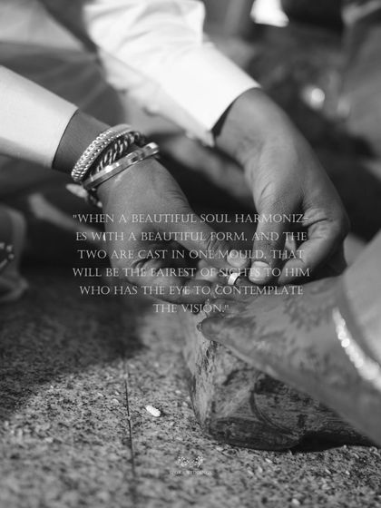 A black and white close-up of a wedding ritual involving the couple's feet, symbolizing their journey together.
