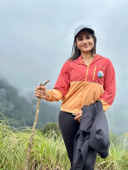 A trekker posing on the Kurinjal trail, which is hidden inside the heart of Kudremukh National Park. The trail is a mix of dense shola forests and vast, rolling grasslands.