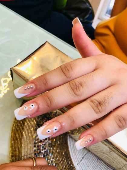 A cute and quirky French manicure with little googly eyes and rhinestone accents.