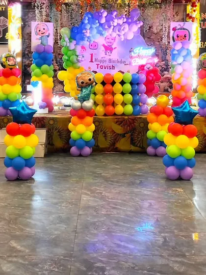 Another view of the vibrant Cocomelon birthday setup, showing the full stage with rainbow balloon columns and star-shaped foil balloons.