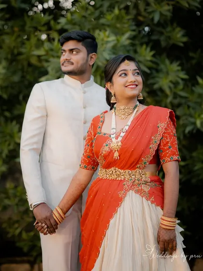 Radiant and glowing! My cherished client Harshitha dazzles on her engagement day in this custom-made red and ivory half saree that I crafted for her in under a week. She looks absolutely stunning.