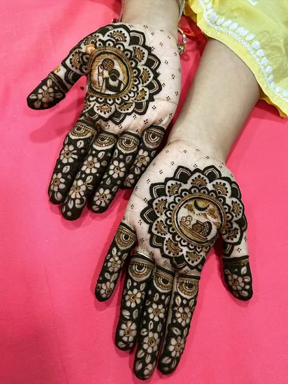 This unique Karwa Chauth mehendi features two distinct scenes within mandala frames. One hand shows the traditional ritual of looking at the moon, while the other depicts a loving couple.
