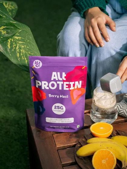A person preparing an Alt Co. protein shake in a relaxed, outdoor setting. This image demonstrates the product's ease of use in a healthy, natural context.
