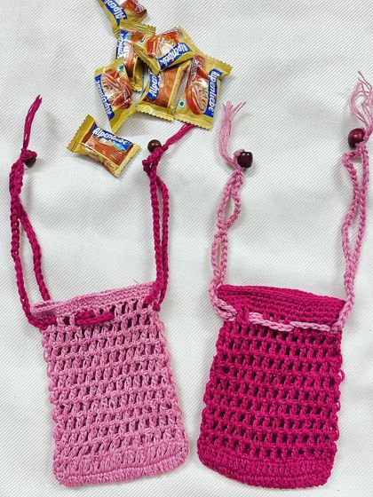 Another view of the two pink crochet pouches, perfect for gifting or using as a soap saver bag. The simple yet durable stitch makes them a practical and pretty accessory.