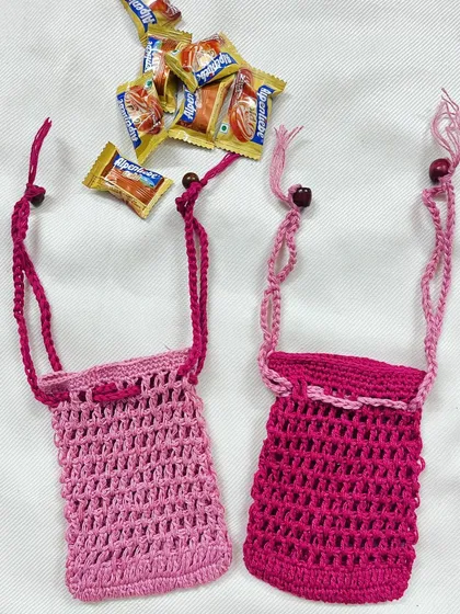 Another view of the versatile pink crochet pouches, highlighting their detailed stitching and drawstring closure with wooden beads.
