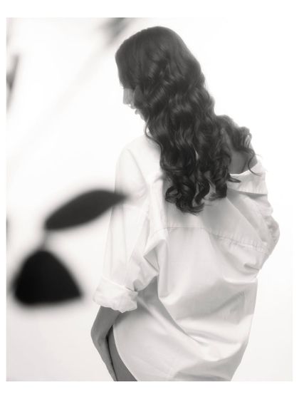 A soft, classic black and white portrait that focuses on form and emotion. It’s a quiet, introspective image that tells a story without ever showing a face.