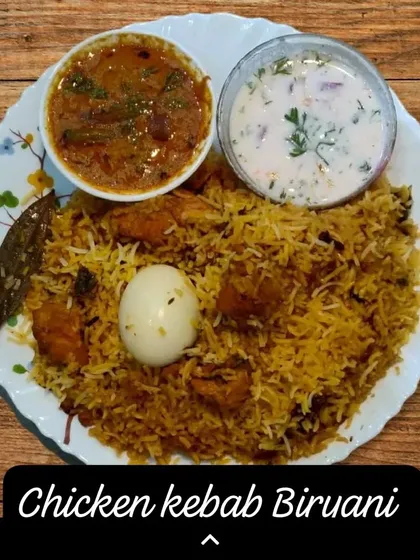 My homemade Chicken Kebab Biryani, plated and ready to be enjoyed. I make it with fragrant basmati rice, tender chicken kebabs, and a blend of spices, served with traditional mirchi ka salan and cooling raita.