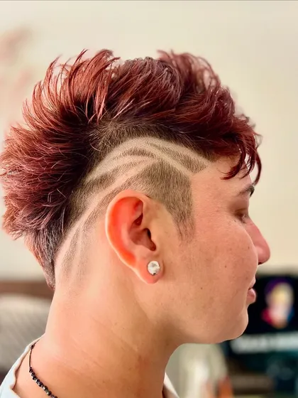 Hair is a canvas for art. This creative hair tattoo, combined with a textured mohawk and rich color, shows how we can push boundaries to create a look that is truly unique and expressive.