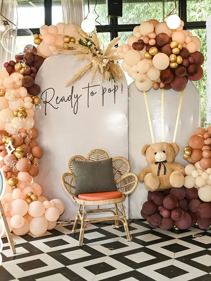 This modern, boho-chic teddy bear setup is perfect for trend-conscious parents. I combined earthy-toned balloons with dried pampas grass and a stylish rattan chair to create a warm, textured, and highly photogenic 'Ready to Pop' photo corner.