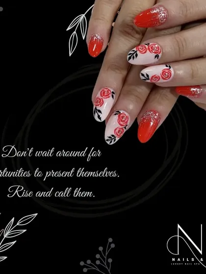 A beautiful example of floral nail art. This design features hand-painted pink roses on a nude base, paired with a bright, glittery red polish for a romantic contrast.