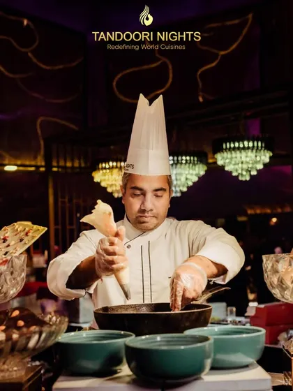 The secret behind our renowned flavors is the chef's touch of perfection in every bite. Here, a chef at a live dessert station crafts a sweet creation, adding a personal and interactive element to the dining experience.