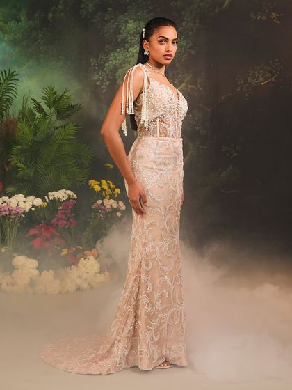 The Nuray Gown, captured from the side to showcase its elegant mermaid silhouette and the delicate pearl tassels that adorn the bodice.