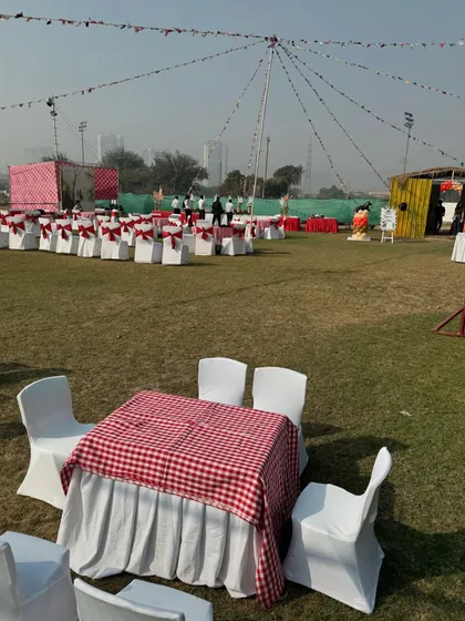 Gingham tablecloths and classic party seating create a charming, rustic picnic vibe for a daytime celebration.