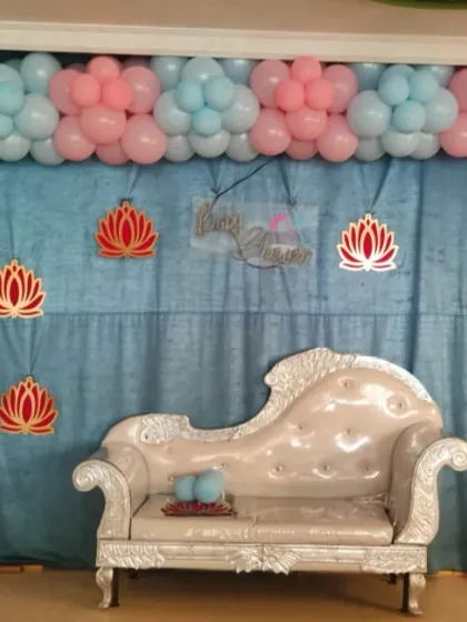 For a modern baby shower, I used a combination of pastel pink and blue balloons to create a floral-style arch. The elegant silver chaise lounge and lotus cutouts complete this gentle and celebratory look.