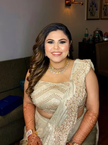 A classic reception look for this lovely bride. The makeup features a soft smokey eye and a neutral lip, paired with beautiful side-swept curls for a timeless appeal.