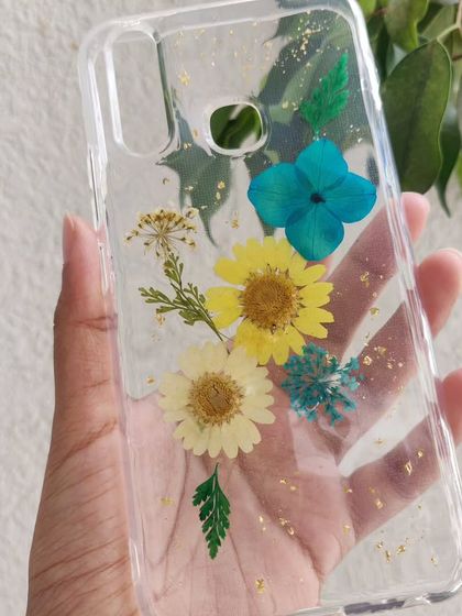 A custom phone case made with real dried flowers. I arranged these yellow and blue daisies and added a sprinkle of gold leaf to create a beautiful, botanical design.
