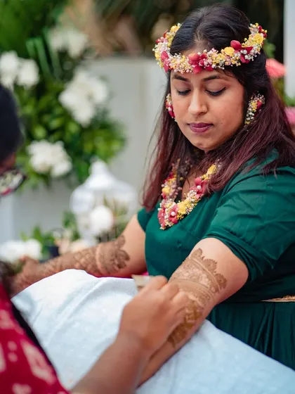 A close-up of the mehndi application in progress, showing the care and precision I bring to every client's design.
