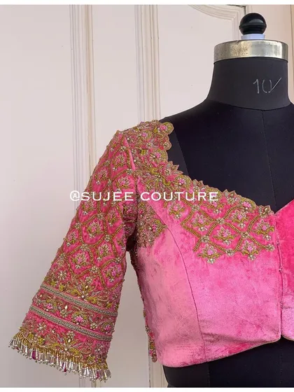 The front of the pink velvet blouse, featuring a sweetheart neckline and intricate embroidery that extends from the shoulders down the sleeves. This piece is a testament to detailed craftsmanship.