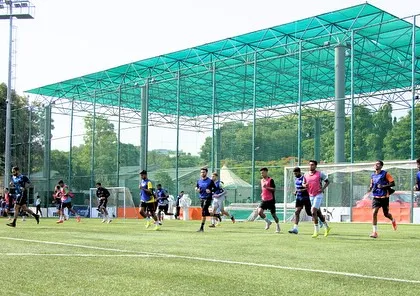 Athletes engaged in a high-intensity running drill on the turf. This captures the energy and effort required during our conditioning sessions, which are designed to replicate the physical demands of a match.