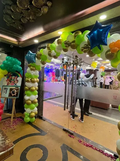 The entrance decor for a Cocomelon party, featuring a large, multi-colored balloon arch.