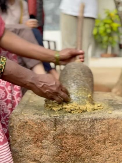 Our artisans demonstrate the traditional method of grinding myrobalan, a natural tannin, in a stone grinder. This ingredient is essential for fixing color in the natural dyeing process, a technique we share in our workshops.