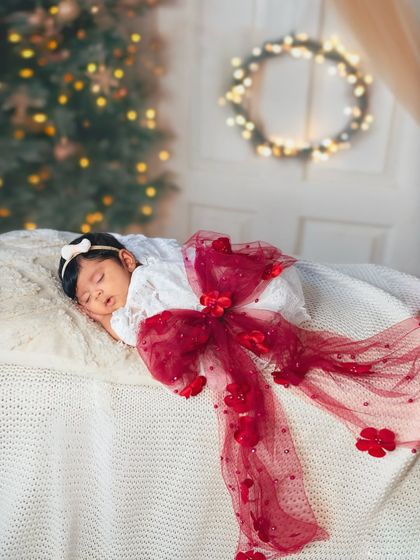 The most precious gift of all. This two-month-old is wrapped up like a Christmas present, a creative and adorable concept for a holiday milestone session.