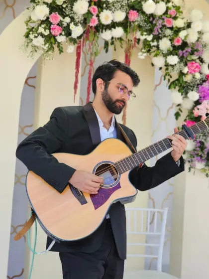 Playing the guitar at a beautiful wedding reception. The floral decor and elegant setting called for a mix of classic love songs and soft acoustic numbers.