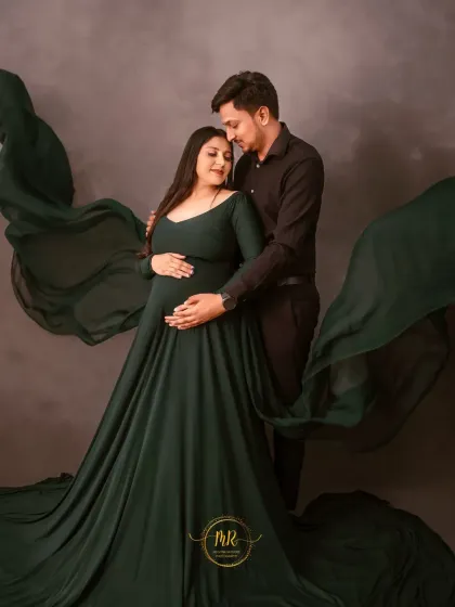 This is an example of my dramatic maternity photography. The deep green flowing gown and moody, textured background create a powerful, fine-art portrait for this expecting couple.
