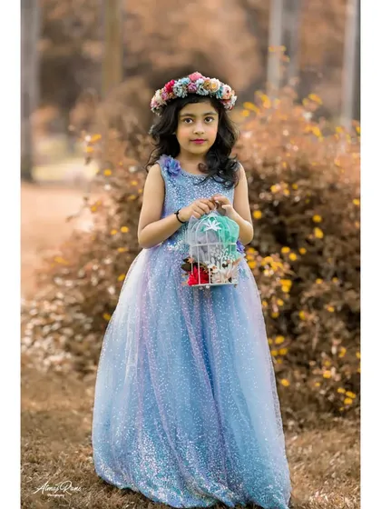 Kids' photoshoots aren't just for toddlers. Here, seven-year-old Brishka looks like a fairytale princess in her beautiful blue gown, complete with a floral crown and whimsical birdcage prop for her birthday portraits.
